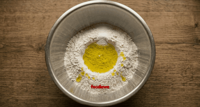Whole wheat flour with salt and oil in a steel mixing bowl - for egg paratha dough