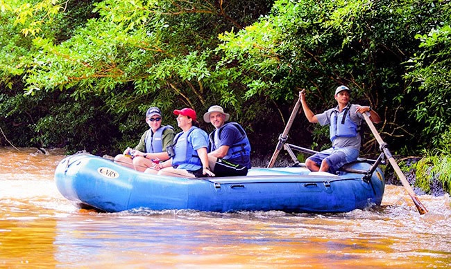 Travelers walking across the thrilling hanging bridges in the lush Heliconias Rain Forest.