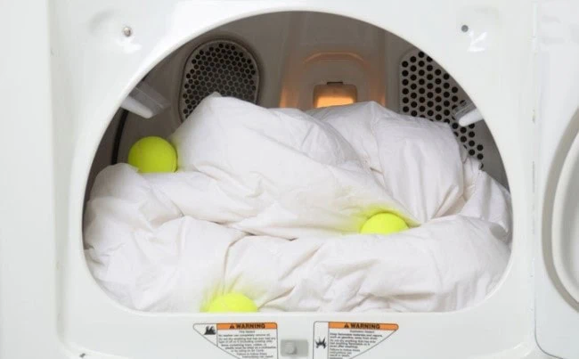 Using tennis balls to fluff a comforter in the drying machine