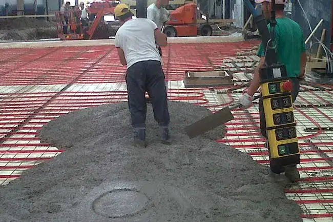 Stabilimento industriale con pavimento in calcestruzzo su impianto radiante Prima Pavimenti — pavimentazione progettata per lavorare con il riscaldamento a pavimento, resistente agli sbalzi termici ciclici, assenza di fessurazioni e distacchi nel tempo