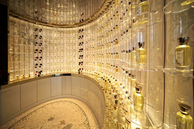 Curved, backlit shelves filled with Annick Goutal perfumes in a Paris boutique. french perfume shops in paris