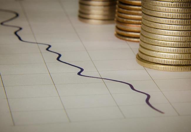Gráfico económico en descenso junto a monedas, reservas internacionales de República Dominicana