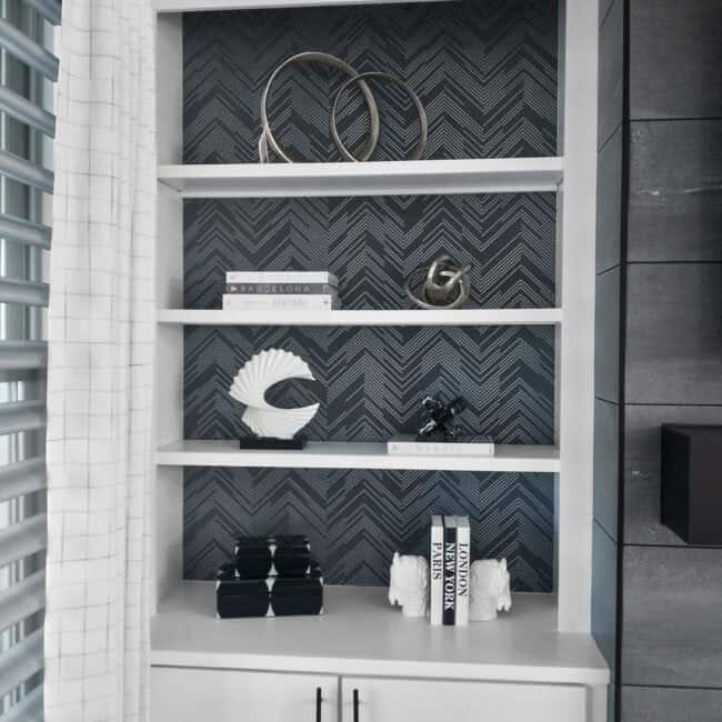 Stylish shelving unit showcasing decorative objects, books, and art pieces in modern home décor.