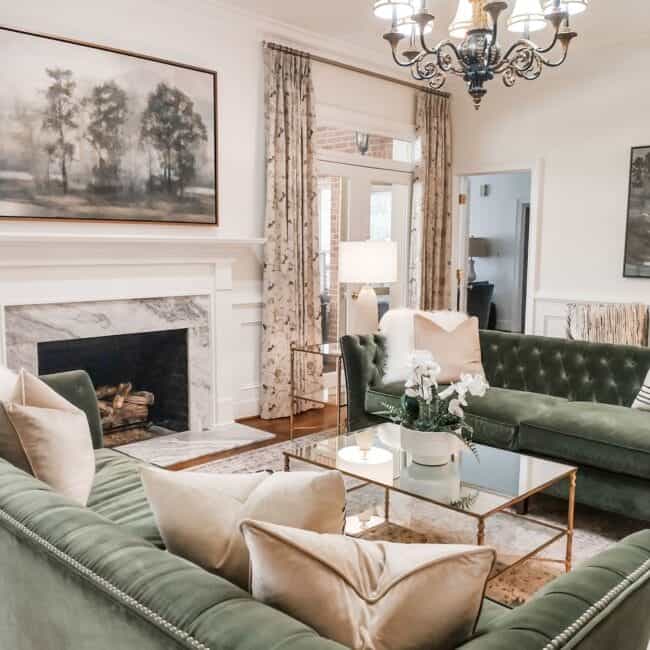 Bright and cozy sitting area with classic chandelier, floral curtains, and soft lighting.