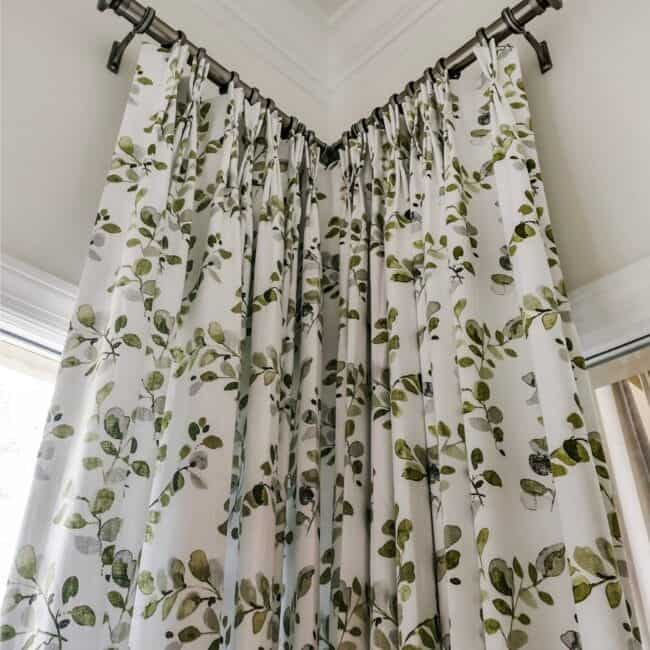 Decorative white curtains with green foliage print, stylish window treatment for living room or bedroom.