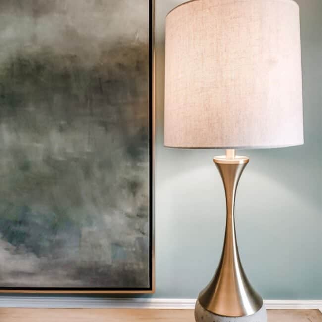 Modern beige lampshade with stylish metallic pedestal, situated on a wooden floor.
