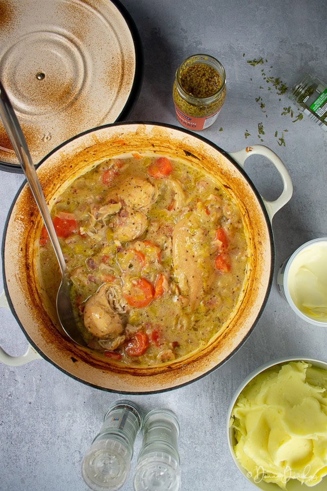 Cider and Chicken casserole in cast iron cooking dish, mustard, tarragon, mash surrounding