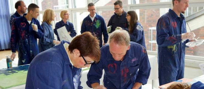 MitarbeiterInnen von Daimler Logistics malen gemeinsam während einer kreativen Teambuilding Aktion ihre neuen Kulturelemente