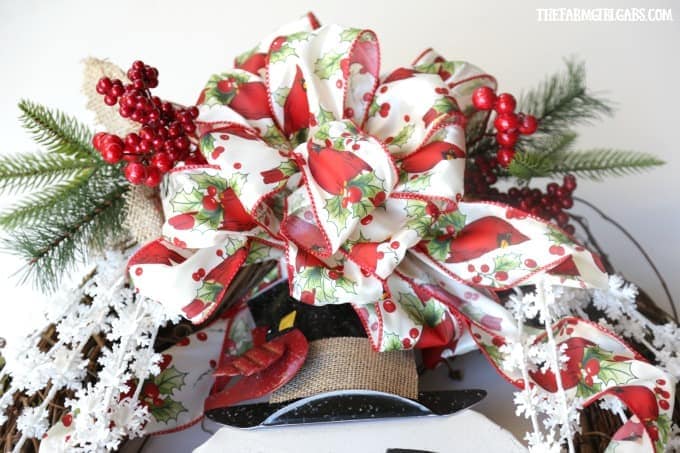 You will also want to wire your snowflake sprays and Christmas picks in place at the top. I used one spray and one pick on each side of the snowman's hat.