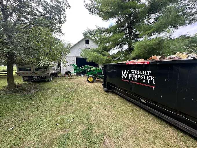 Dumpster rental near barn and equipment