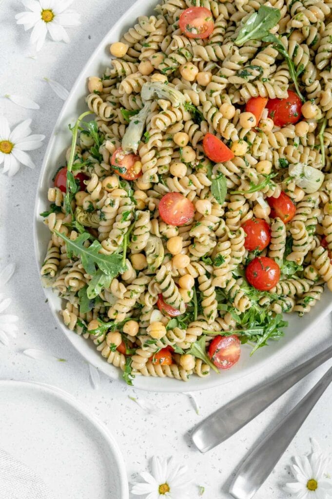 Overhead of a serving platter with vegan pesto pasta salad.