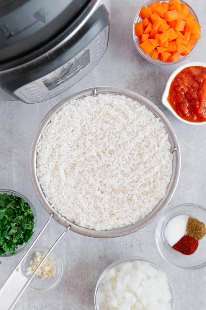 White rice in a strainer being rinsed off.