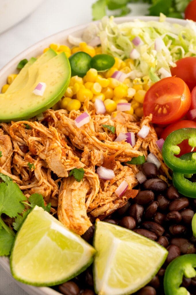 close up of crockpot salsa chicken in a bowl with veggies
