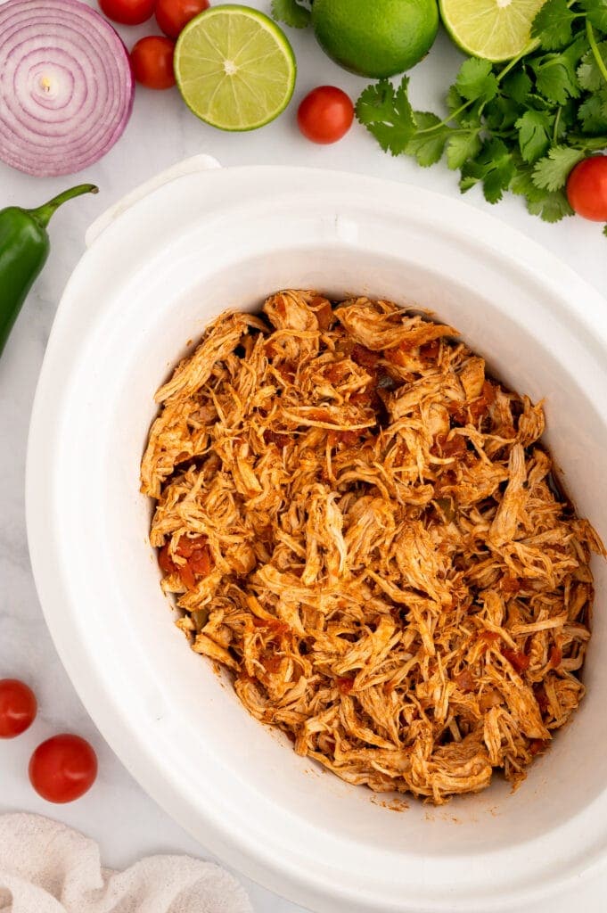 top view of crockpot salsa chicken in a white pot
