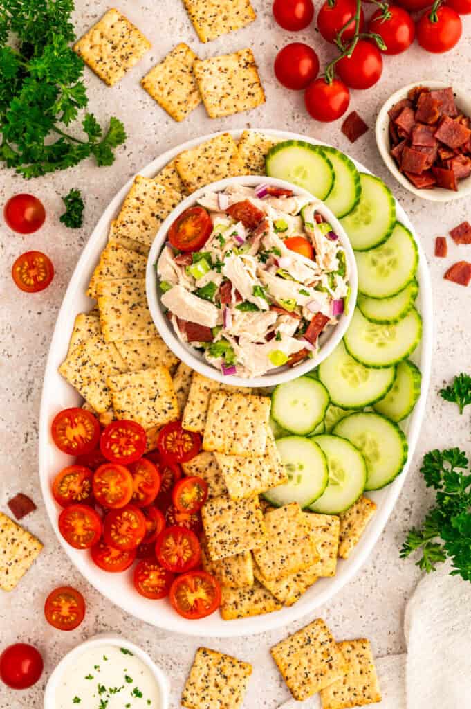 Healthy BLT chicken salad in a bowl on a platter with veggies