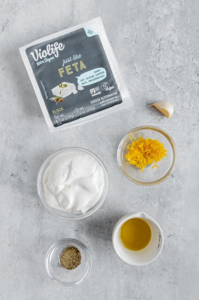 Ingredients to make whipped feta dip in glass bowls.