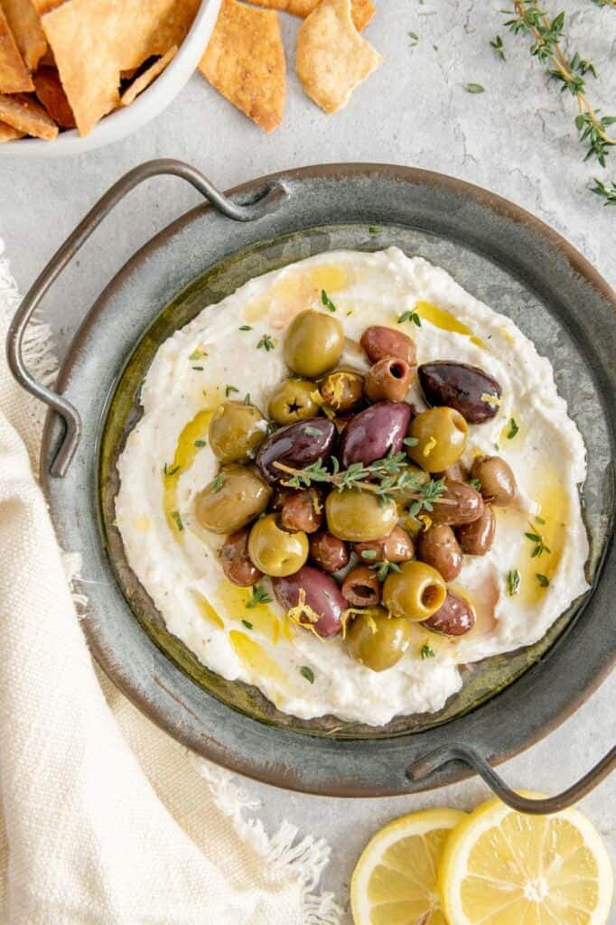 A stunning appetizer of whipped feta garnished with marinated olives.