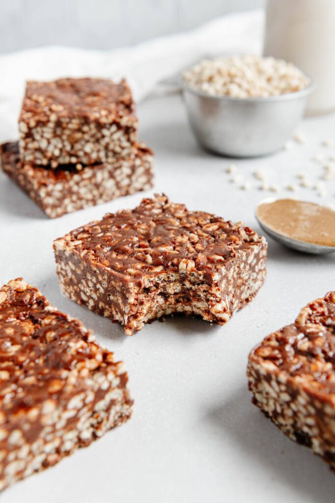 A chocoalte rice krispie treat with a bite taken out of it.