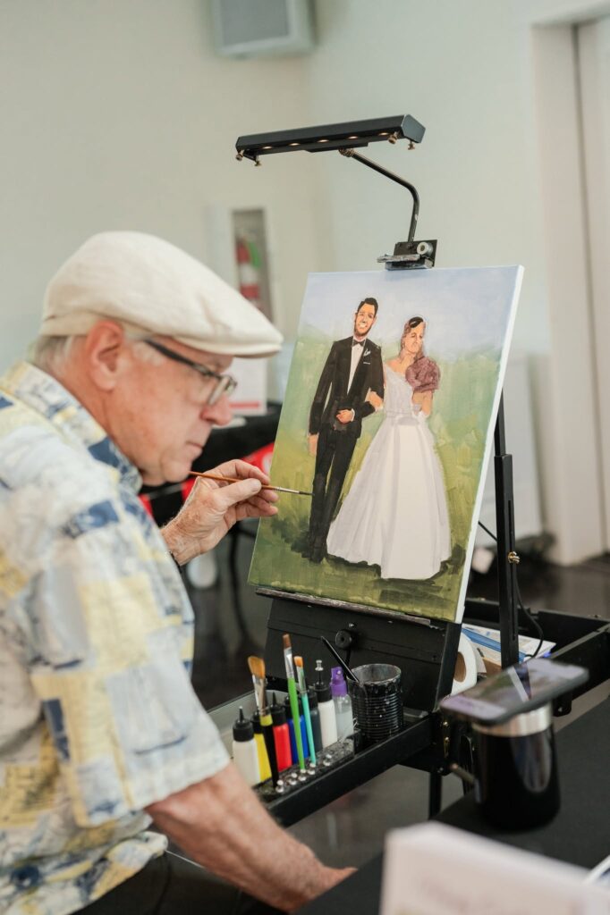 Live wedding painter creating a portrait of the couple at Romaine Valley Weddings & Events in Fenton, Missouri