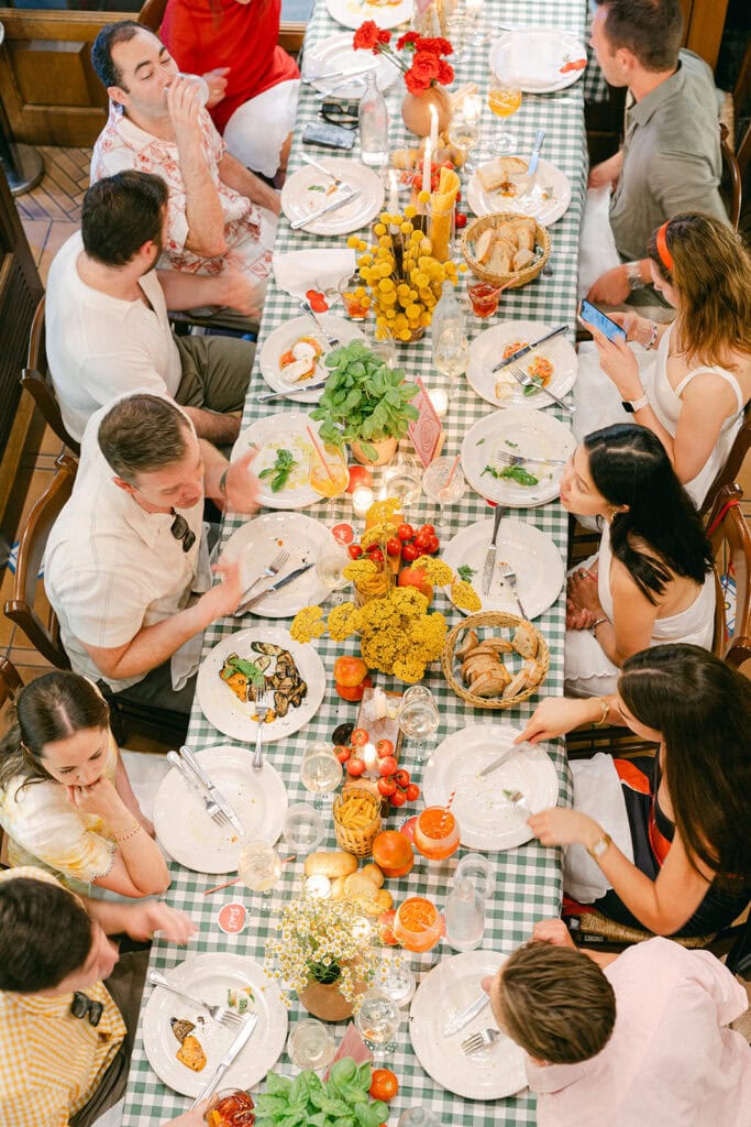 Guests gathered around long tables at an Italy wedding welcome party