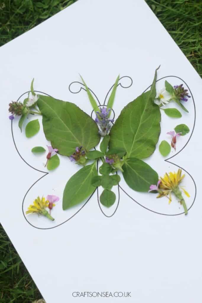 butterfly outline filled with leaves, grass, and flowers