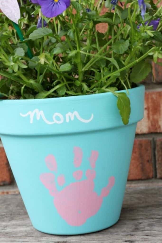 light blue terra cotta pot with pink handprint