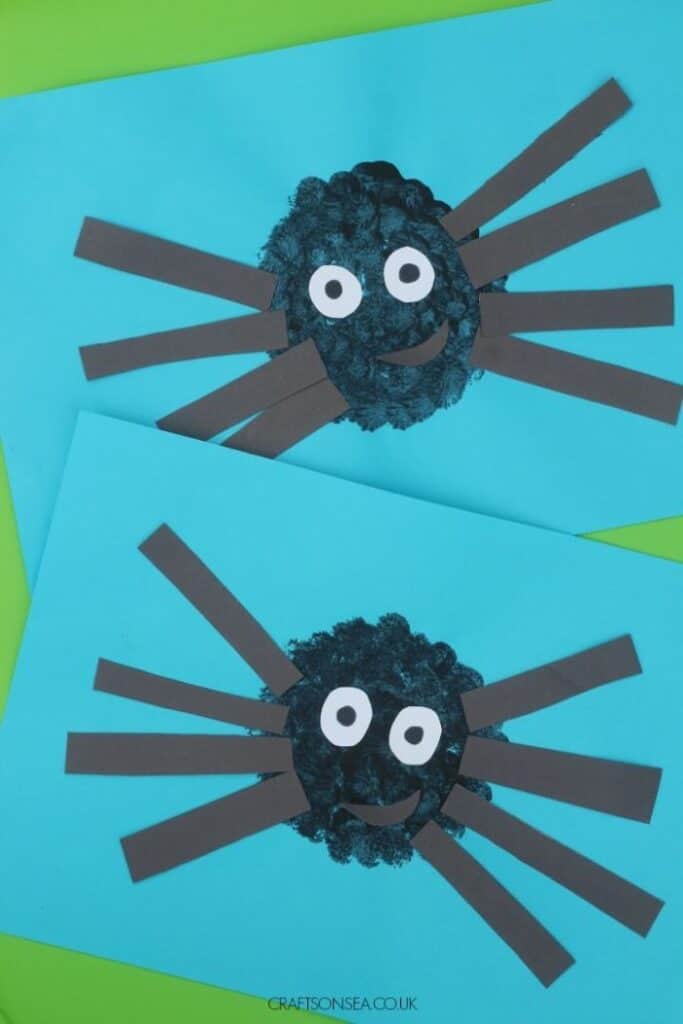 pom pom painted spider craft on blue paper