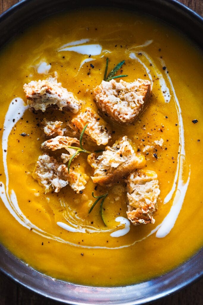 Paula's Apron Crema de Calabaza Asada con Picatostes de Gruyère Esta Crema de Calabaza Asada con Picatostes de Gruyère es sencilla, todo se hace en una bandeja de horno y el asar las verduras hace que quede extra cremosa y con un plus de sabor. Como topping lleva unos picatostes con gruyère que no solo le dan un contrapunto crujiente, sino que además el toque salado del queso balancea el dulzor de la calabaza. En resumen, es un primero nutritivo y saludable perfecto para otoño e invierno.| Receta de Paula's Apron
