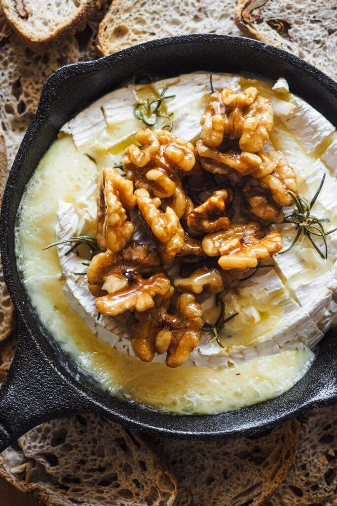 Paula's Apron Garlic Rosemary Baked Camembert with Candied Walnuts Garlic Rosemary Baked Camembert with Candied Walnuts, another must-have holiday appetiser. This recipe is festive, easy to prepare and it’s one that the crowd always loves! Quick, a handful of ingredients and super delicious. The garlic and rosemary provide an incredible aroma to the Camembert, already a bit fruity and earthy. To serve, some toasts and a top notch addition, some maple syrup candied walnuts, which you can also use as a dip or as an addition to any cheese and charcuterie board. | Paula's Apron Recipe