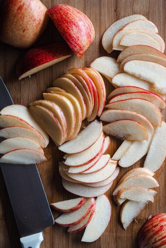 Paula's Apron Apple Bacon Cheddar Puff Pastry Bites Sliced apple on a wooden board next to a knife.