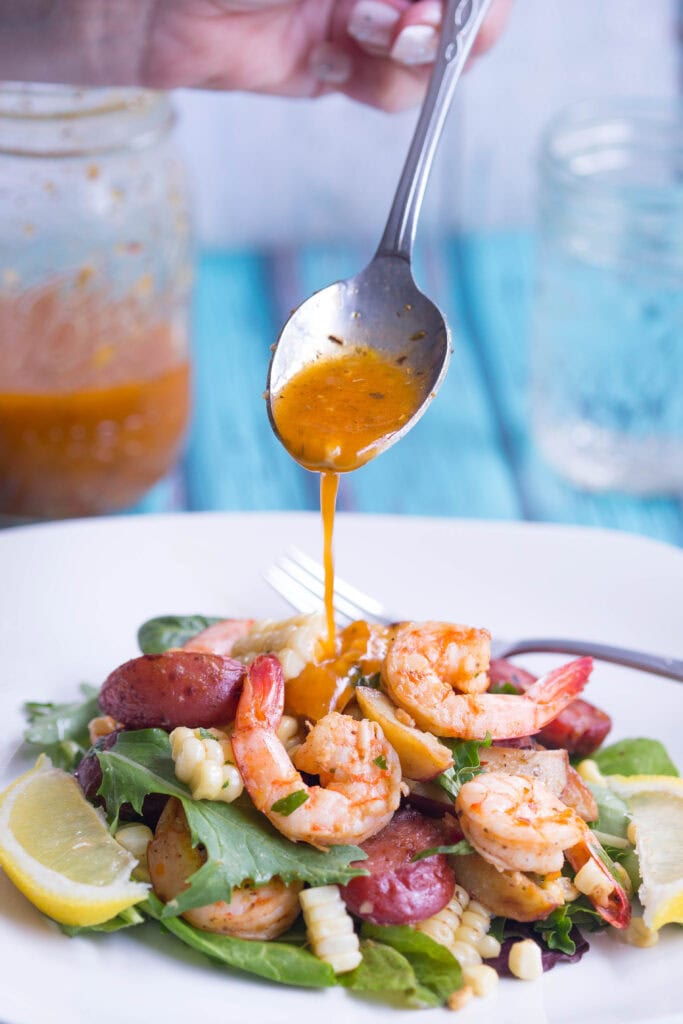 Lowcountry Boil Salad being drizzled with Old Bay Vinaigrette