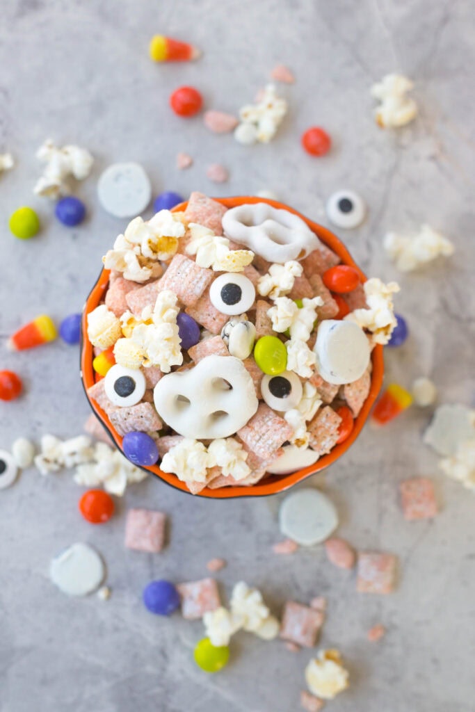 Overhead flat lay shot of popcorn mix with white pretzels and orange muddy buddies