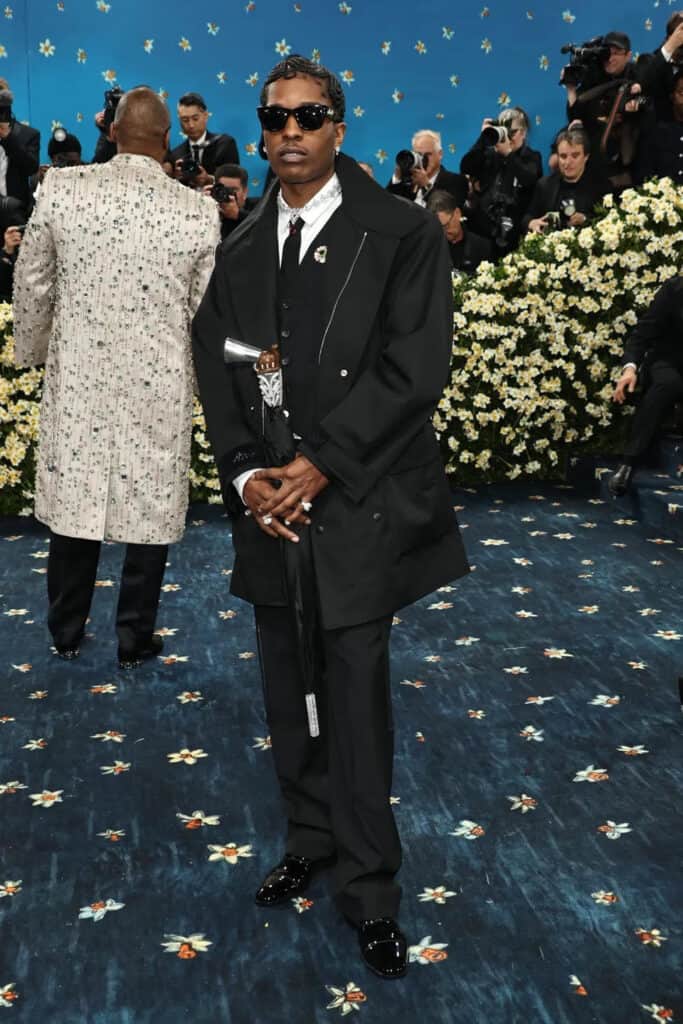 Guest in sharp black tailoring and diamond details at the Met Gala 2025, channeling timeless Dandy elegance and contemporary edge.