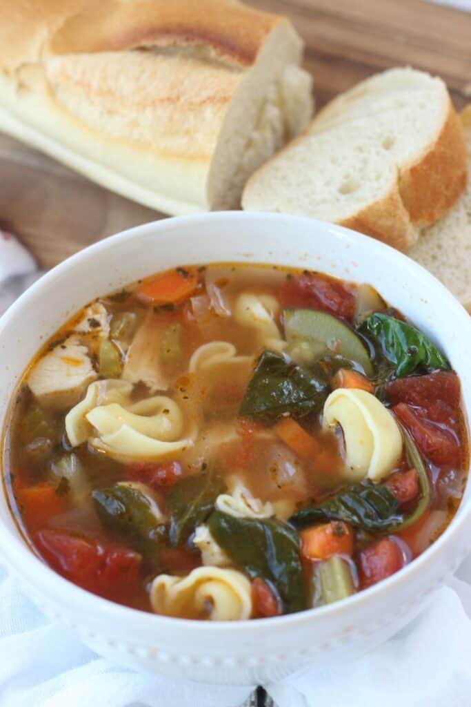 This classic Tuscan Chicken Soup will warm you up on a cold winter's day! This easy soup recipe is filled with hearty vegetables, chicken and tortellini. This Italian-style chicken soup is easy to prepare and is filled with spinach too. It can be easily prepared in a slow cooker, making it a delicious slow cooker chicken soup or an easy Instant Pot Soup recipe.