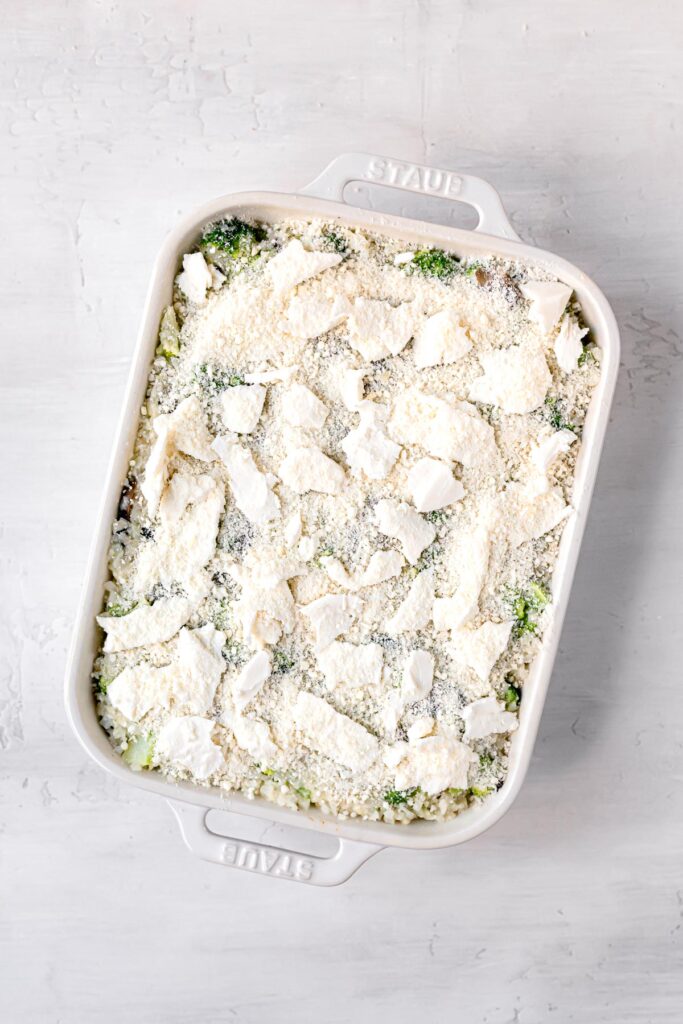 top shot of casserole being topped with cheese