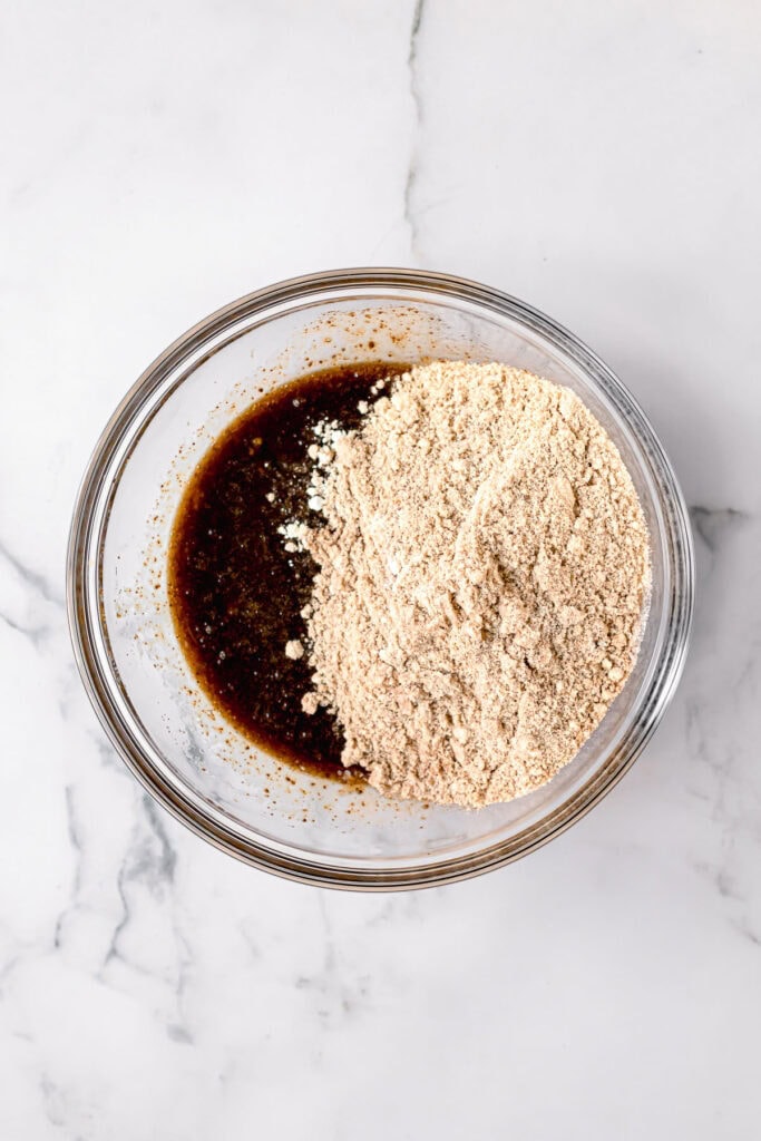 ingredients to make paleo carrot cake in a glass bowl