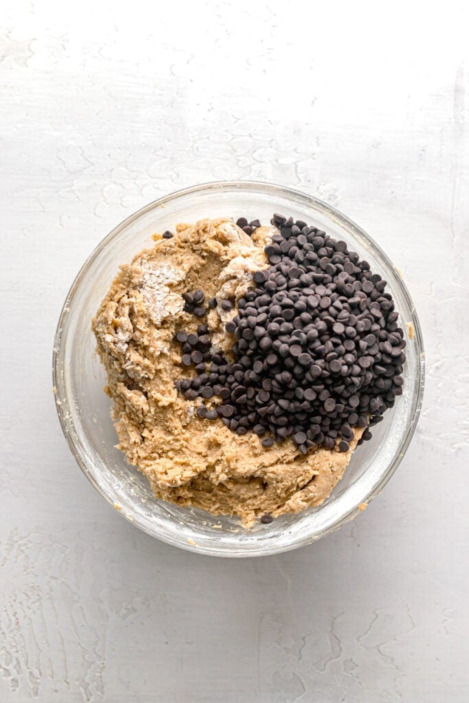 chocolate chips being added to the cookie dough