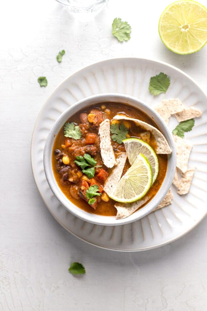 healthy vegan taco soup in a bowl with garnishes 