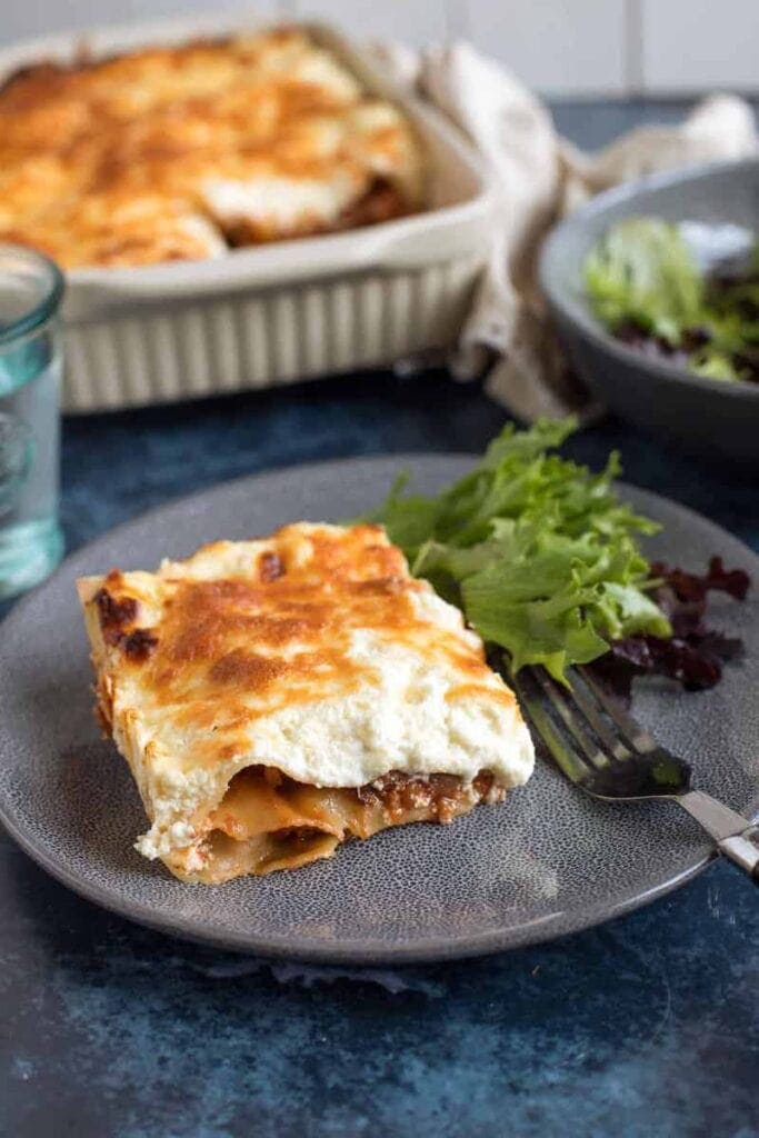 Effortless Foodie's Easy Lasagne served with a salad on a blue plate in the Winter Warming Oven Bakes CookBlogShare round up.