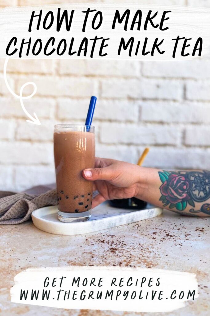 glass of chocolate milk tea, boba pearls in a glass container behind, towel - pin image