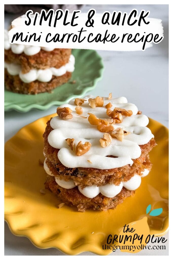Mini Carrot Cake Recipe, The Perfect Easter Dessert 11 A mini carrot cake with two layers, filled and topped with piped cream cheese frosting and chopped walnuts, sits on a yellow scalloped plate. Another mini carrot cake is visible in the background on a green plate. The image includes text that reads "SIMPLE & QUICK mini carrot cake recipe" in a playful font, with "the GRUMPY Olive" logo and website URL at the bottom.