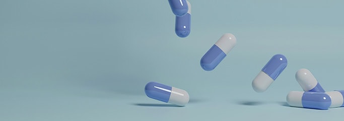 capsules for treatment fall to the surface on a blue background