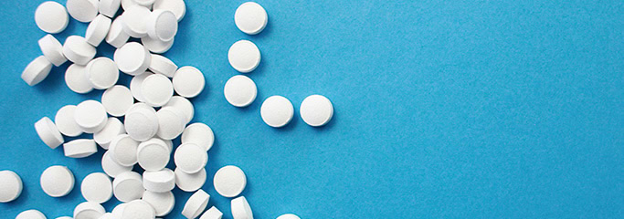 a package with scattered tablets on a blue background