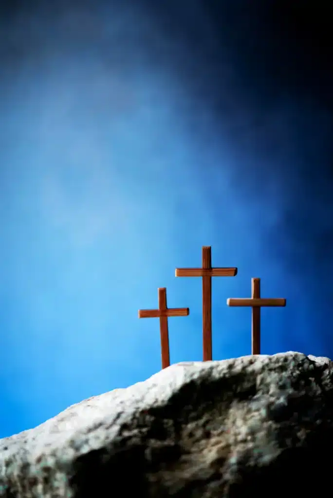 three wooden cross on calvary hill blue background