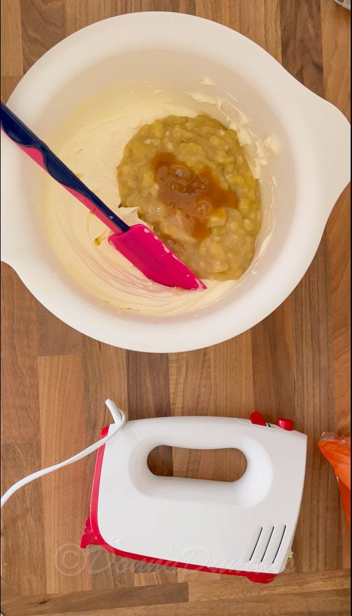 toffee sauce on mashed banana and cream in mixing bowl.