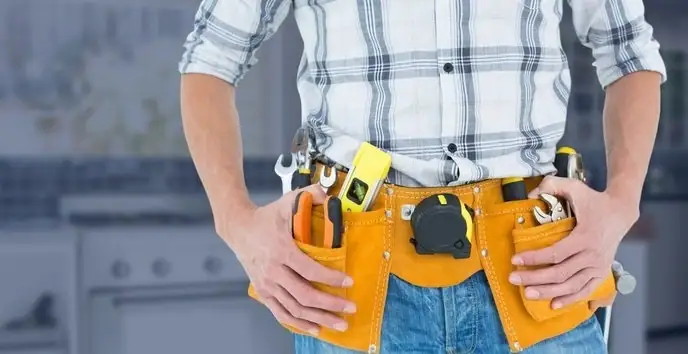 Common handyman homeowners need fixing a kitchen cabinet in a modern home.