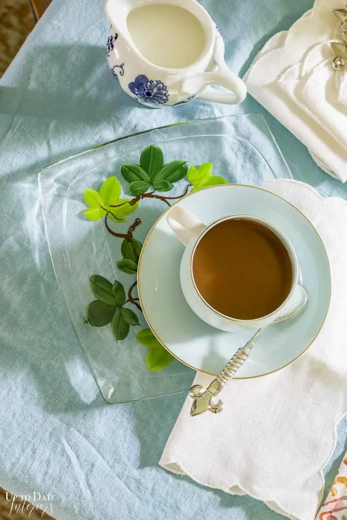 coffee in blue cup and saucer on blue tablecloth