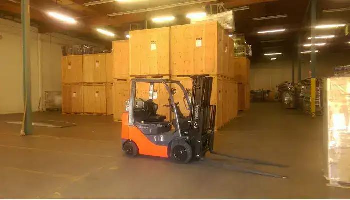 Interior of Eden's secured Denver storage warehouse with wooden storage vaults and a forklift moving inventory
