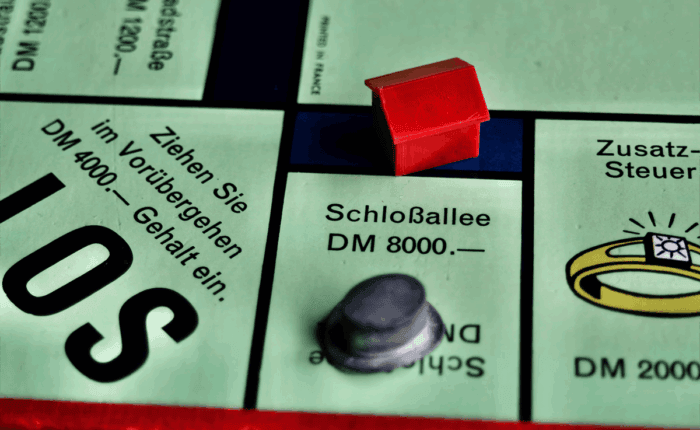 Ausschnitt eines deutschen Monopoly-Spiels mit Haus auf der Schlossallee.