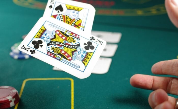 Kartenspiel im Casino mit einigen Jetons im Hintergrund.